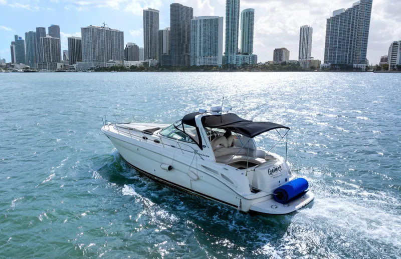 Slide: The Image of 2003 Sea Ray 380 Sundancer cruising near city skyline on sunny day. - 39
