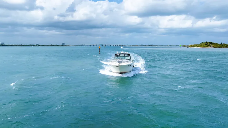 Slide: The Image of 2003 Sea Ray 380 Sundancer cruising on open water under cloudy skies. - 41