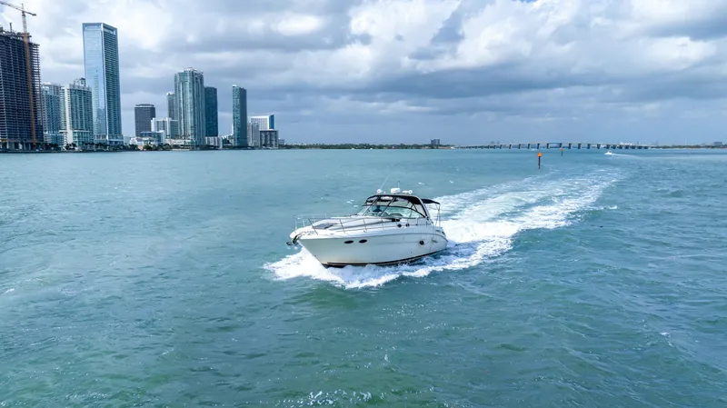 Slide: The Image of 2003 Sea Ray 380 Sundancer cruising near city skyline under cloudy skies. - 42