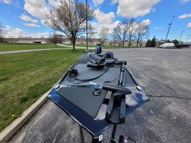 Slide: The Image of 2025 Tracker Bass Tracker Classic XL boat parked on asphalt near grassy area, under cloudy sky. - 4