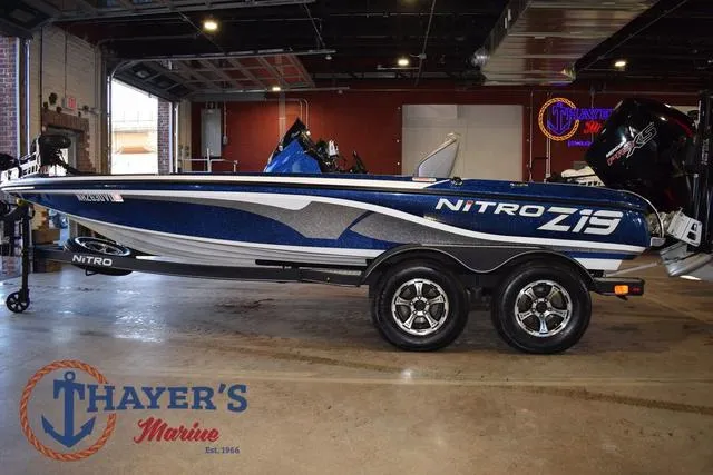 Slide: The Image of 2019 Nitro Z19 boat in showroom, blue and white design, displayed at Thayer's Marine. - 6