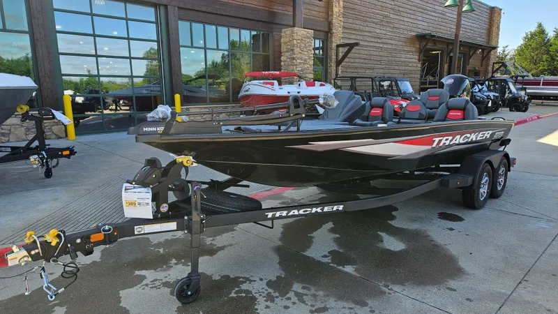 Slide: The Image of 2025 Tracker Savage 215 boat on trailer outside a showroom. - 3