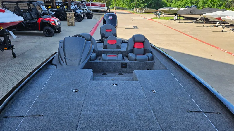 Slide: The Image of 2025 Tracker Savage 215 boat with spacious deck and seating, parked outdoors. - 4