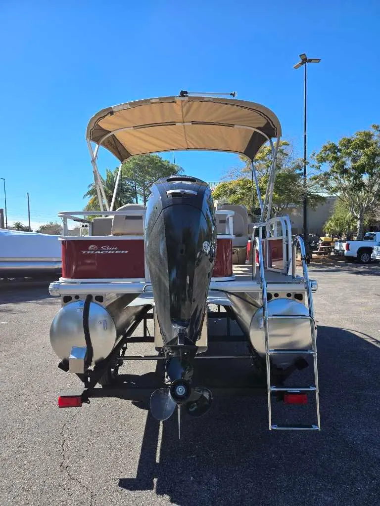 Slide: The Image of 2025 Sun Tracker Bass Buggy 18 DLX pontoon boat with canopy and outboard motor. - 2