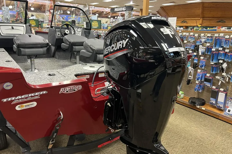 Slide: The Image of 2025 Tracker Pro Guide V-16 WT boat with Mercury outboard motor in showroom. - 2