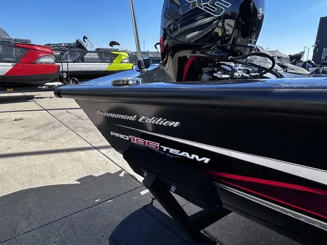 Slide: The Image of 2023 Tracker Pro Team 195 TXW Tournament Edition boat, black with red accents, docked outdoors. - 12