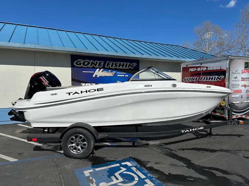 Slide: The Image of 2025 Tahoe 185 S boat on trailer, parked outside a store with "Gone Fishin'" sign. - 0