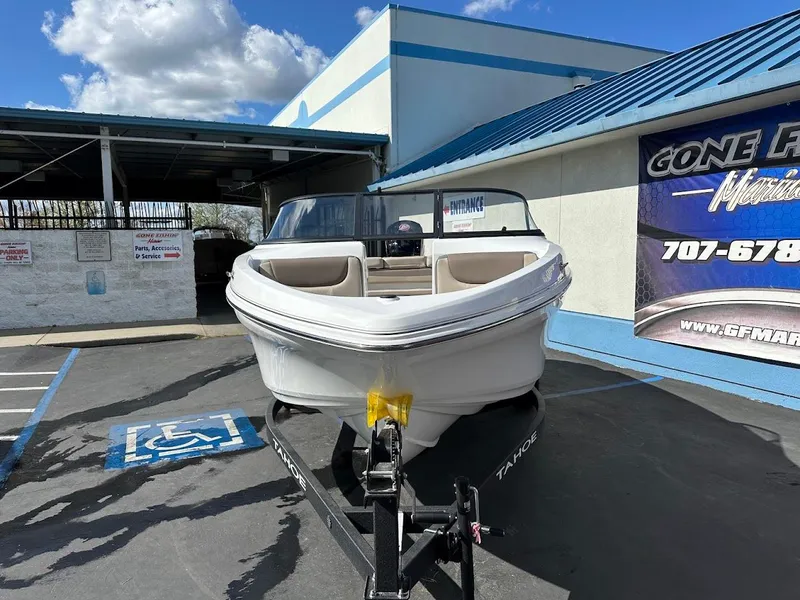 Slide: The Image of 2025 Tahoe 185 S boat on trailer, parked outside dealership under blue sky. - 2