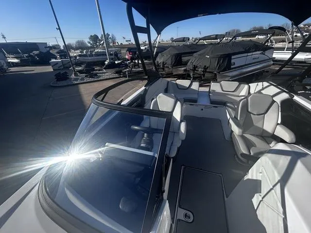 Slide: The Image of 2023 Yamaha Boats AR250 interior with sleek seating and modern design in a marina setting. - 15