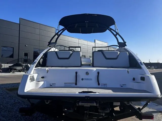 Slide: The Image of 2023 Yamaha Boats AR250, rear view, sleek design, modern architecture in background. - 5