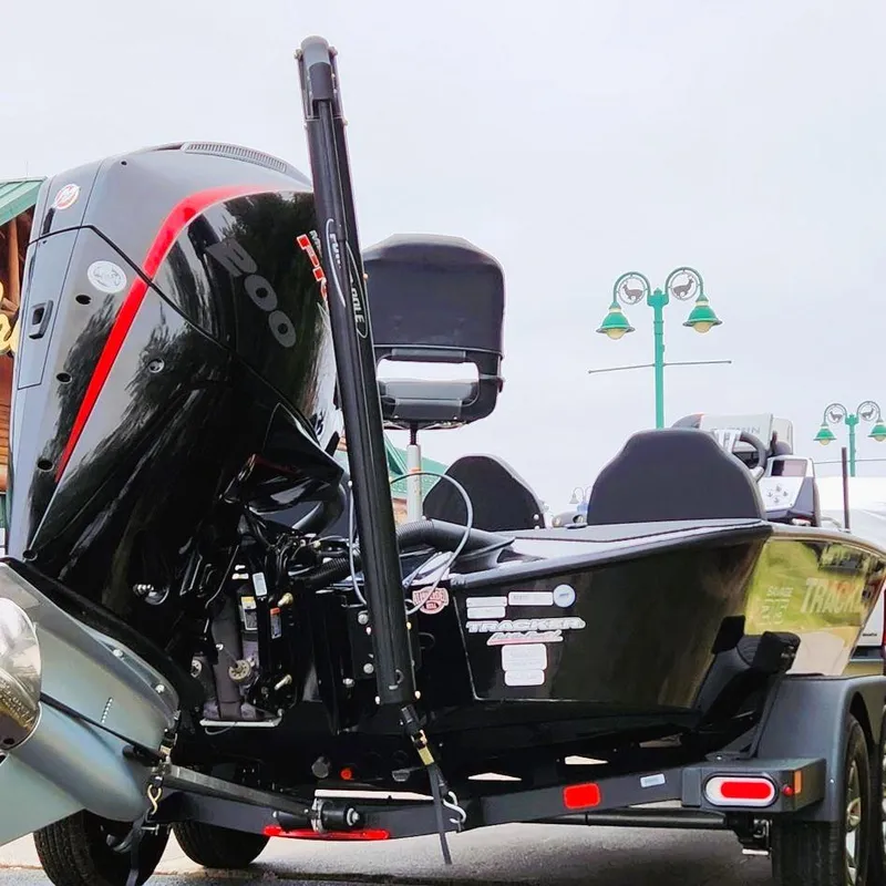 Slide: The Image of 2025 Tracker Savage 215 boat with powerful outboard motor, parked on a trailer. - 2