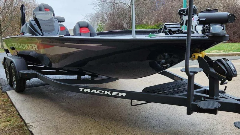 Slide: The Image of 2025 Tracker Savage 215 boat on trailer, sleek black design, parked outdoors. - 3