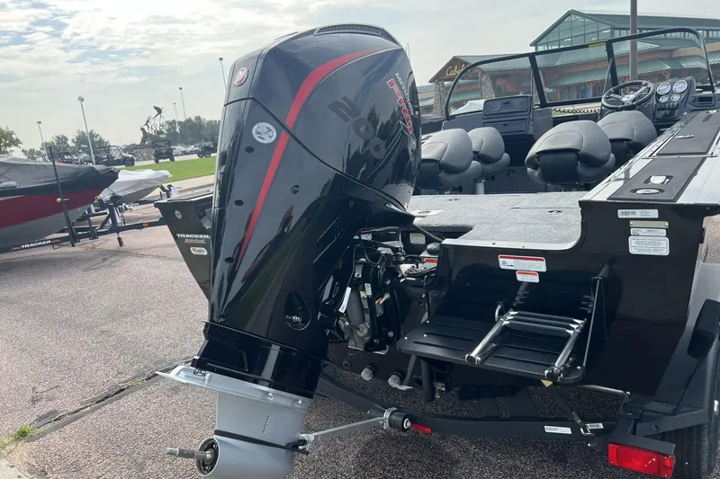 Slide: The Image of 2025 Tracker Targa V-18 Combo boat with powerful outboard motor, parked outdoors. - 2