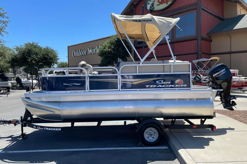 The Image of 2025 Sun Tracker Bass Buggy 16 XL Select pontoon boat on trailer, outdoor store background. - 0