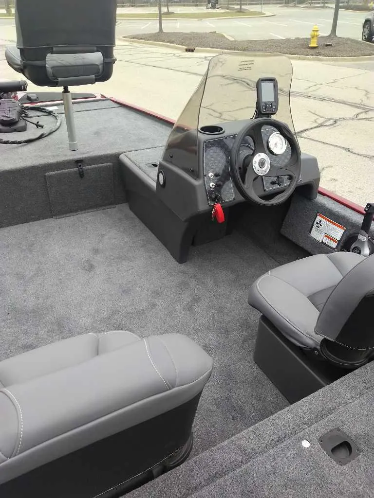 Slide: The Image of 2025 Tracker Bass Tracker Classic XL boat interior with steering console and seating. - 2