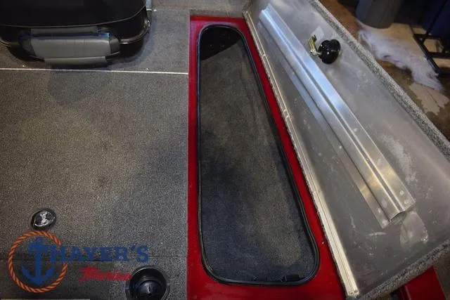 Slide: The Image of 2021 Tracker Pro Team 175 boat interior with storage compartment and carpeted flooring. - 21