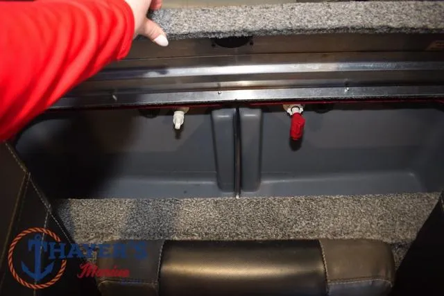 Slide: The Image of 2021 Tracker Pro Team 175 storage compartment with carpeted interior and visible plumbing connections. - 22