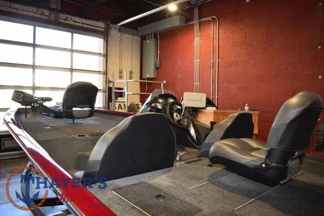 Slide: The Image of 2021 Tracker Pro Team 175 boat interior with seats and steering wheel in a garage setting. - 8