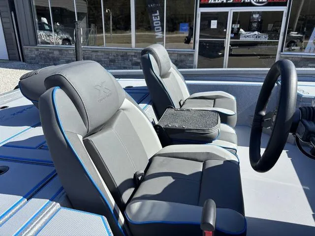 Slide: The Image of 2025 Xpress H20 boat interior with gray seats and blue accents, steering wheel visible. - 7