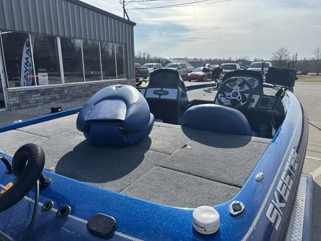 Slide: The Image of 2008 Skeeter ZX200 boat with blue seating and steering wheel, parked outdoors. - 4