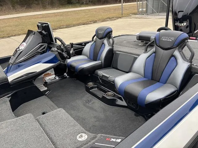 Slide: The Image of 2021 Skeeter FXR21 Limited boat interior with blue and gray seating, steering console, and storage. - 12