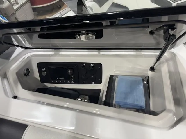 Slide: The Image of 2025 Nautique Super Air Nautique GS20 storage compartment with audio controls and accessories. - 13