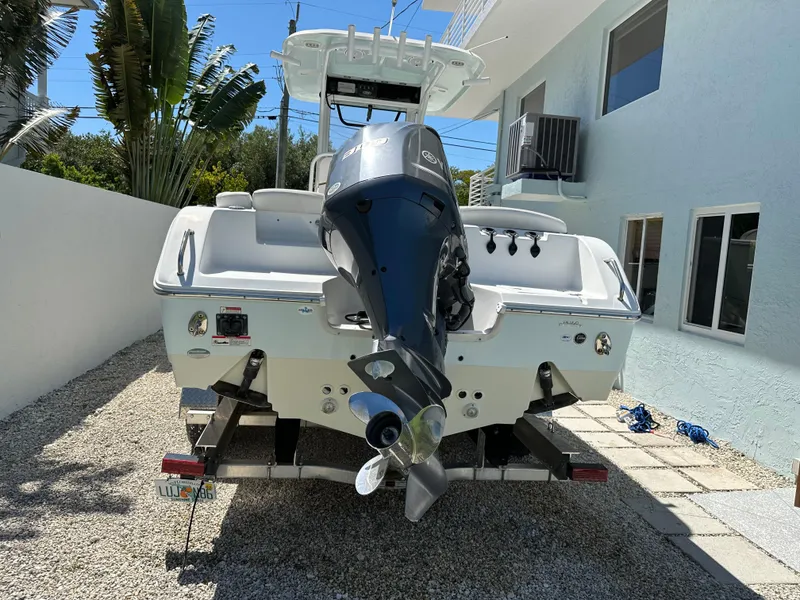 Slide: The Image of 2019 Sea Hunt Ultra 255 SE boat with outboard motor, parked on gravel driveway. - 2