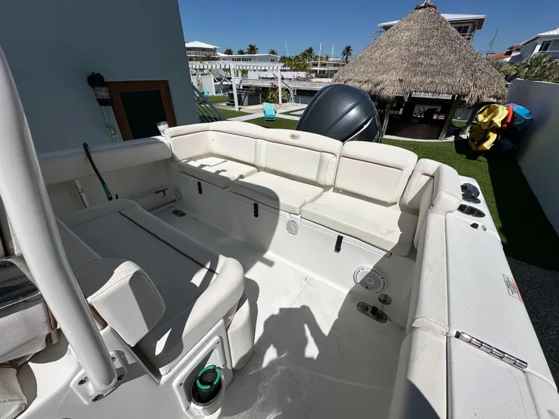Slide: The Image of 2019 Sea Hunt Ultra 255 SE boat interior with white seating and outdoor view. - 3