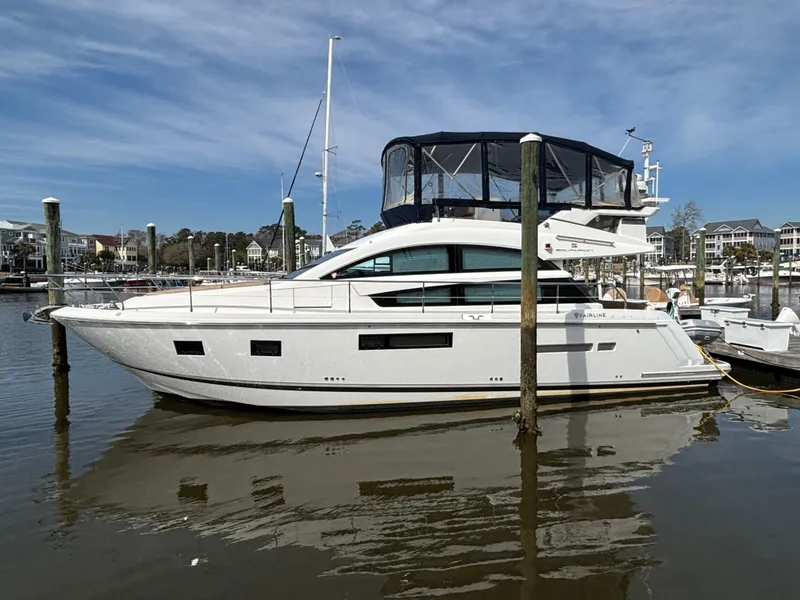 Slide: The Image of 2015 Fairline Squadron 42 yacht docked in a marina under a clear sky. - 0