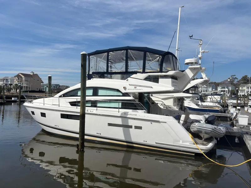 Slide: The Image of 2015 Fairline Squadron 42 yacht docked at marina, clear sky background. - 1