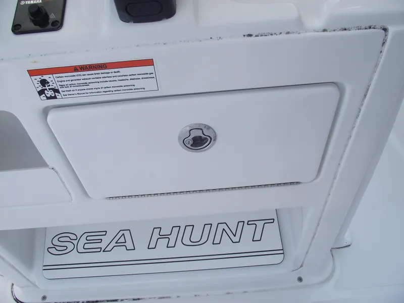 Slide: The Image of 2017 Sea Hunt Ultra 211 boat compartment with warning label and logo. - 21