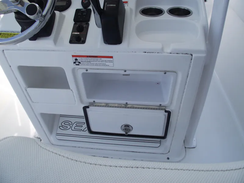 Slide: The Image of 2017 Sea Hunt Ultra 211 boat console with storage and controls. - 22