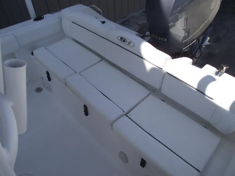 Slide: The Image of 2017 Sea Hunt Ultra 211 boat interior with cushioned seating and motor. - 24