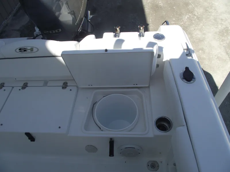 Slide: The Image of 2017 Sea Hunt Ultra 211 boat interior with storage compartment and fishing rod holders. - 26