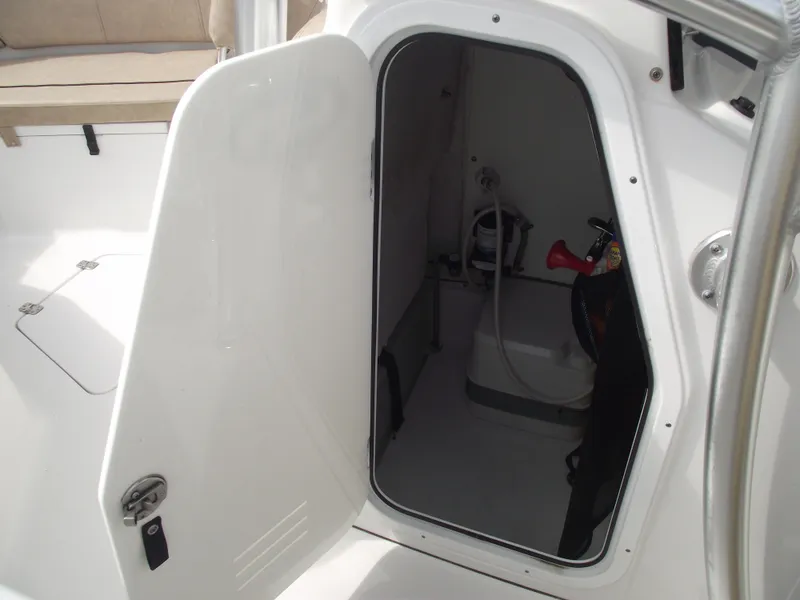 Slide: The Image of 2019 Sportsman Open 232 Center Console boat storage compartment with open door. - 21