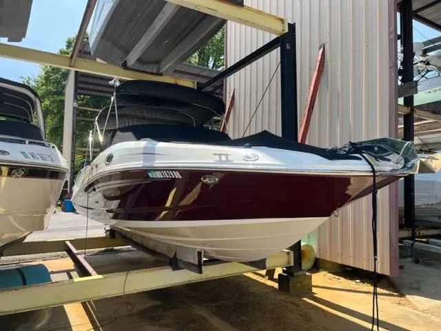 Slide: The Image of 2008 Sea Ray 290 Sundeck boat in storage, maroon and white exterior. - 0