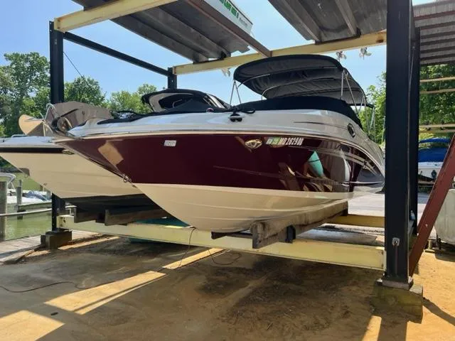 Slide: The Image of 2008 Sea Ray 290 Sundeck boat on lift, maroon and white, docked at marina. - 1