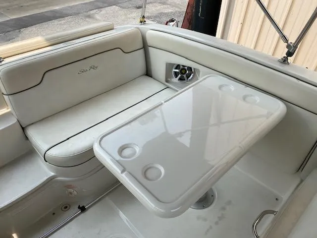 Slide: The Image of 2008 Sea Ray 290 Sundeck interior with white seating and table, featuring cup holders. - 19