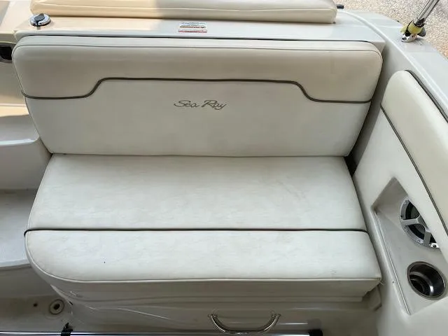 Slide: The Image of 2008 Sea Ray 290 Sundeck boat seating with white upholstery and cup holders. - 24