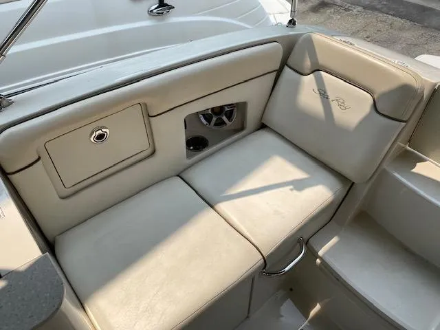 Slide: The Image of 2008 Sea Ray 290 Sundeck interior seating with storage compartment and beige upholstery. - 27