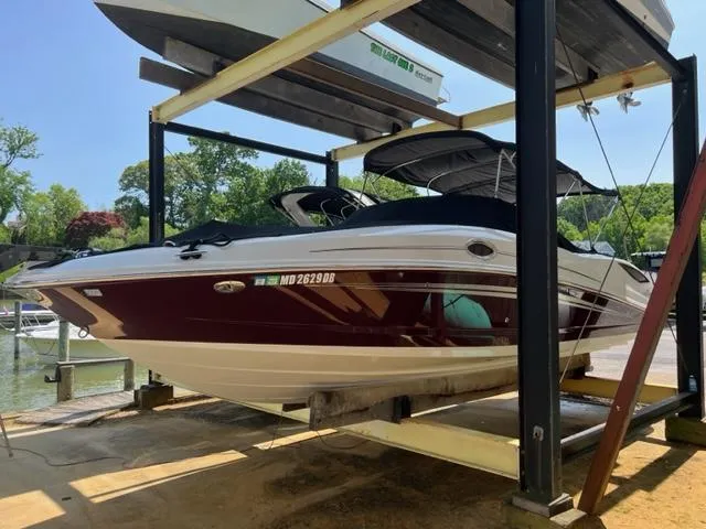 Slide: The Image of 2008 Sea Ray 290 Sundeck boat on lift, maroon and white, dockside view. - 3