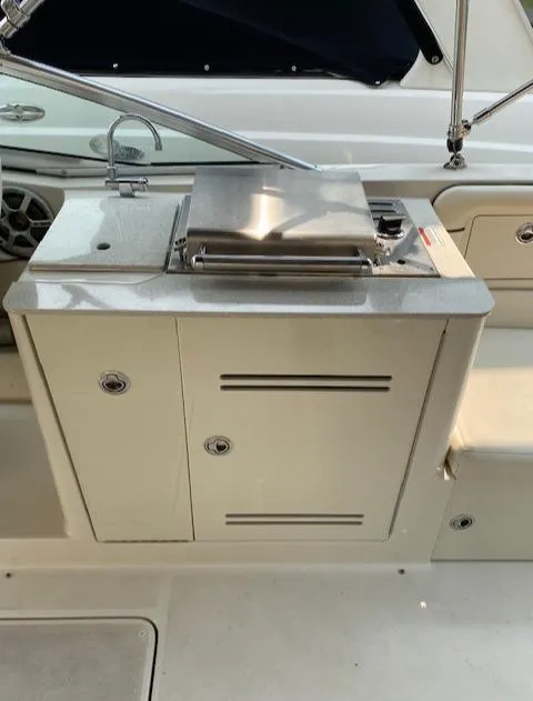 Slide: The Image of 2008 Sea Ray 290 Sundeck boat with built-in grill and storage compartments. - 36