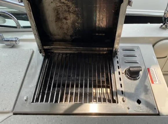 Slide: The Image of Built-in grill on 2008 Sea Ray 290 Sundeck boat, open lid, stainless steel surface. - 37