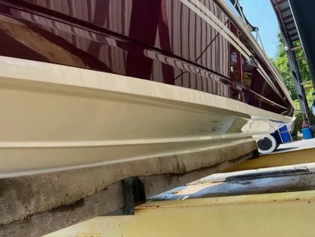 Slide: The Image of 2008 Sea Ray 290 Sundeck boat hull on a lift, showcasing sleek design and glossy finish. - 7