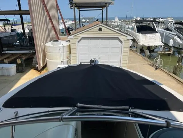 Slide: The Image of 2008 Sea Ray 290 Sundeck with black cover docked near a marina. - 9