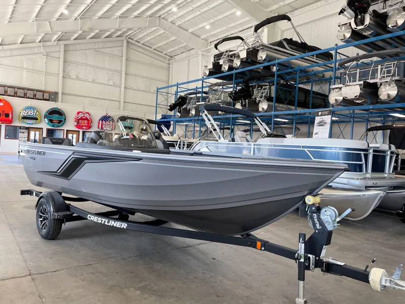 Slide: The Image of 2025 Crestliner 1750 Hawk boat in showroom, displayed on a trailer. - 0