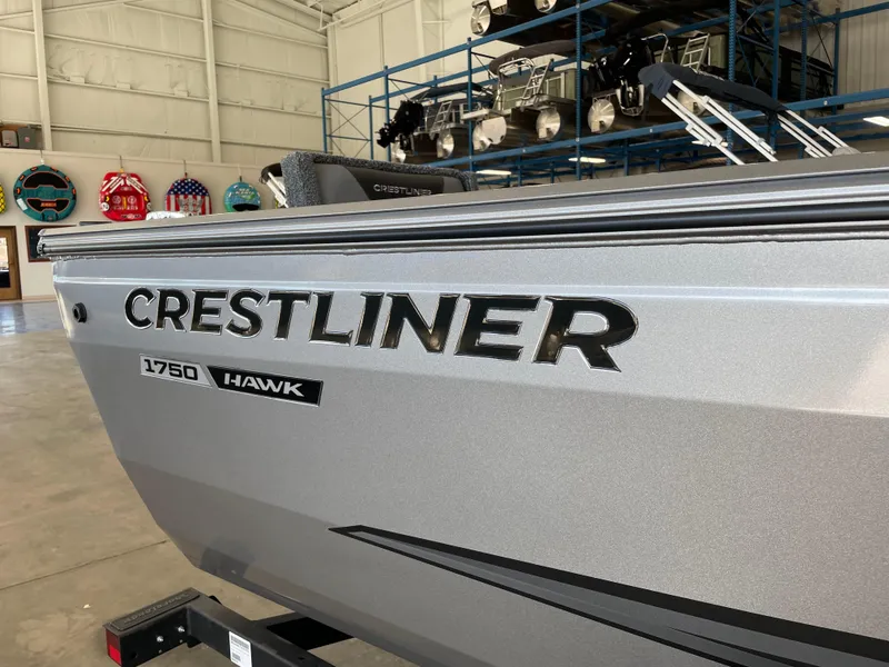 Slide: The Image of 2025 Crestliner 1750 Hawk boat in showroom, showcasing sleek design and branding. - 11