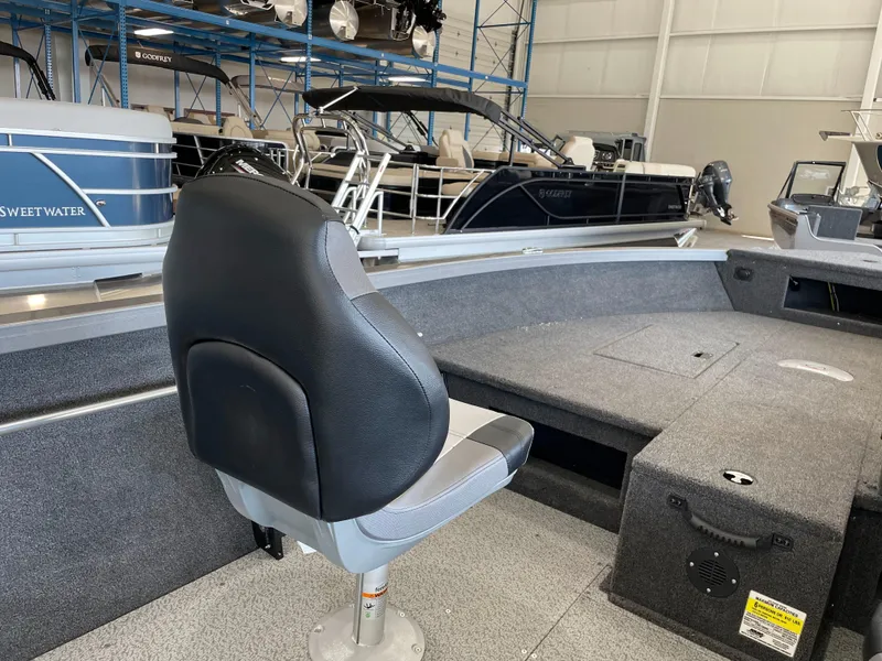 Slide: The Image of 2025 Crestliner 1750 Hawk interior with seating and storage in a showroom. - 12