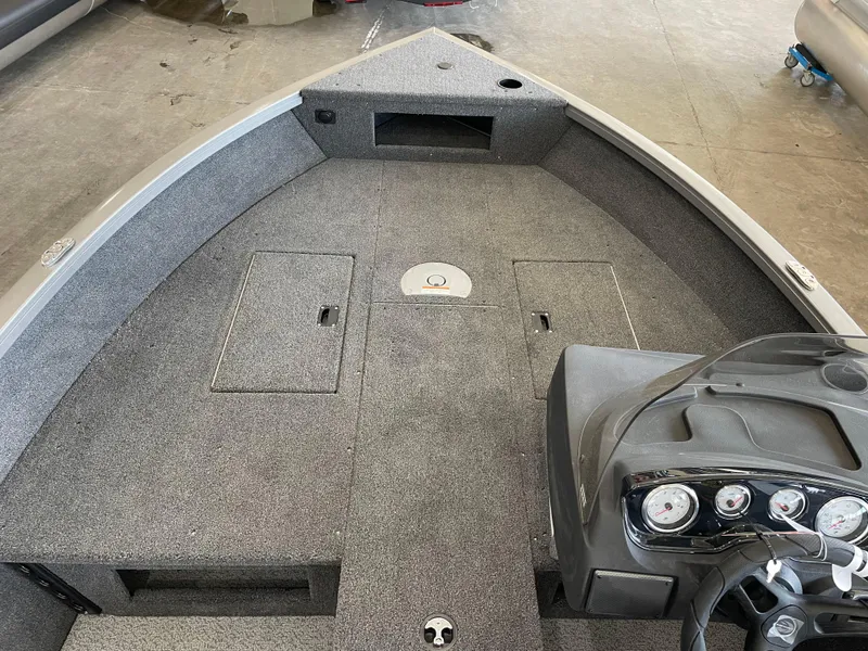 Slide: The Image of 2025 Crestliner 1750 Hawk boat interior with gray carpet and control panel. - 14