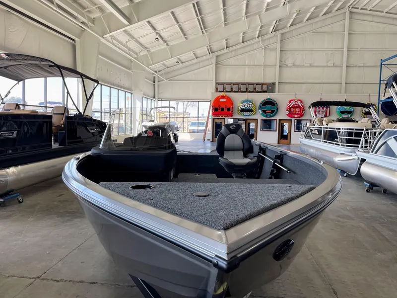 Slide: The Image of 2025 Crestliner 1750 Hawk boat displayed in a spacious showroom. - 2